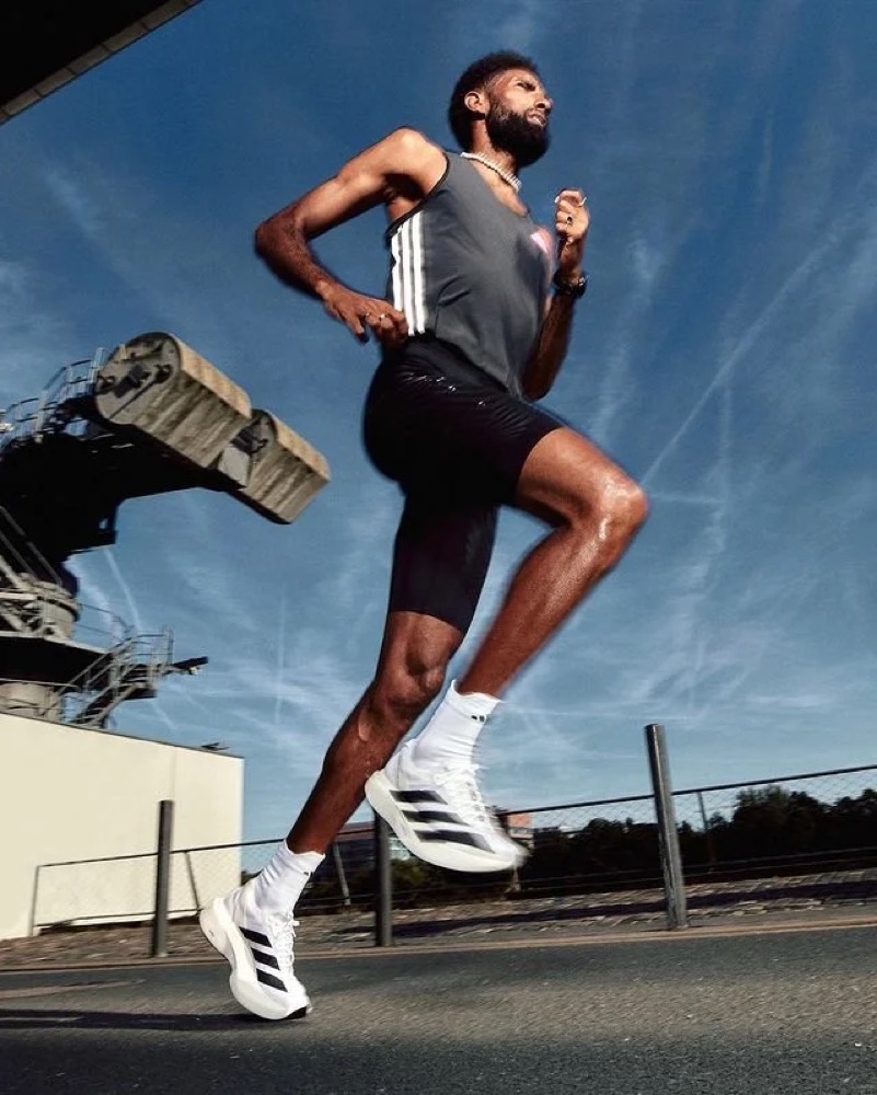Amanal Petros läuft vor blauem Himmel an einem Kran vorbei, adidas Running
