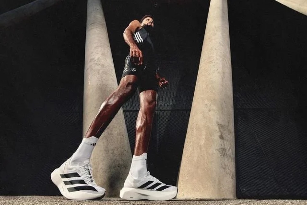 Amanal Petros läuft in adidas-Schuhen zwischen Betonpfeilern