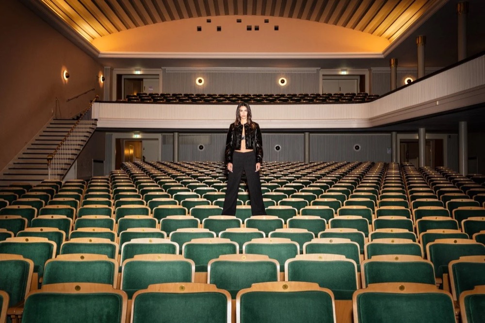 Model steht in einem leeren Kino mit grünen Sesseln, Angels-Jeans-Kampagne HW24 in Freudenstadt