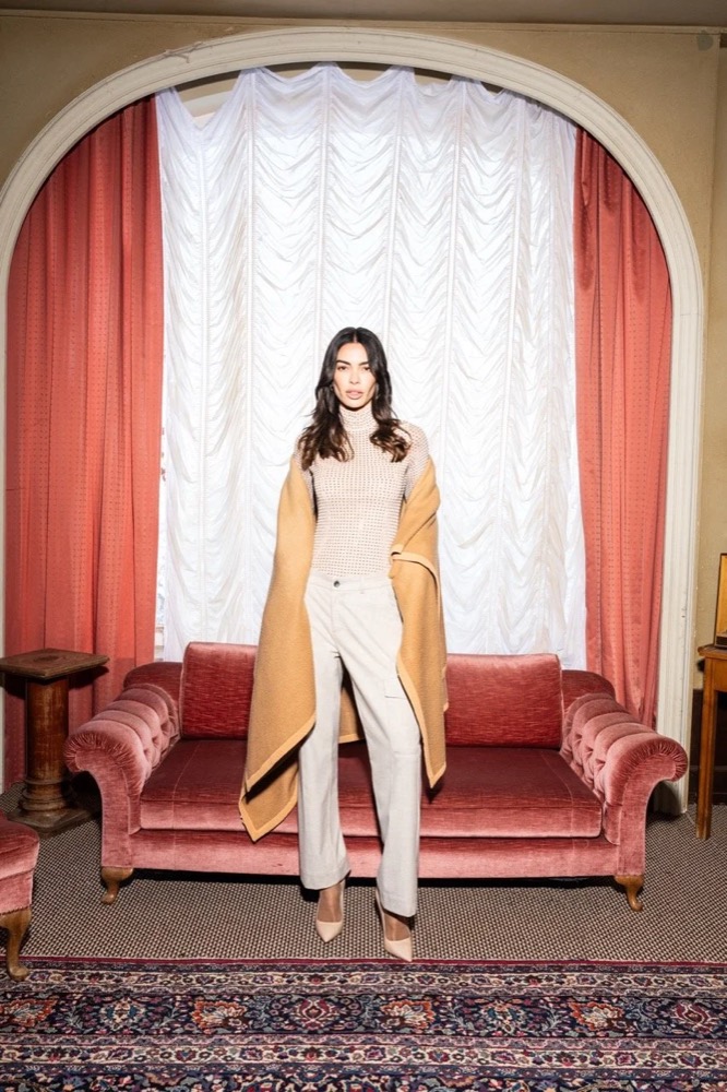 Model in kamelfarbenem Mantel vor einem roten Sofa, Angels-Jeans-Kampagne HW24 in Freudenstadt