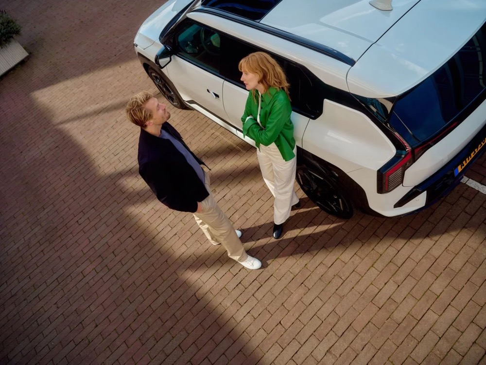 Mann und Frau im Gespräch neben einem Auto im Business-Umfeld, Shooting für Athlon Car Lease in Amsterdam