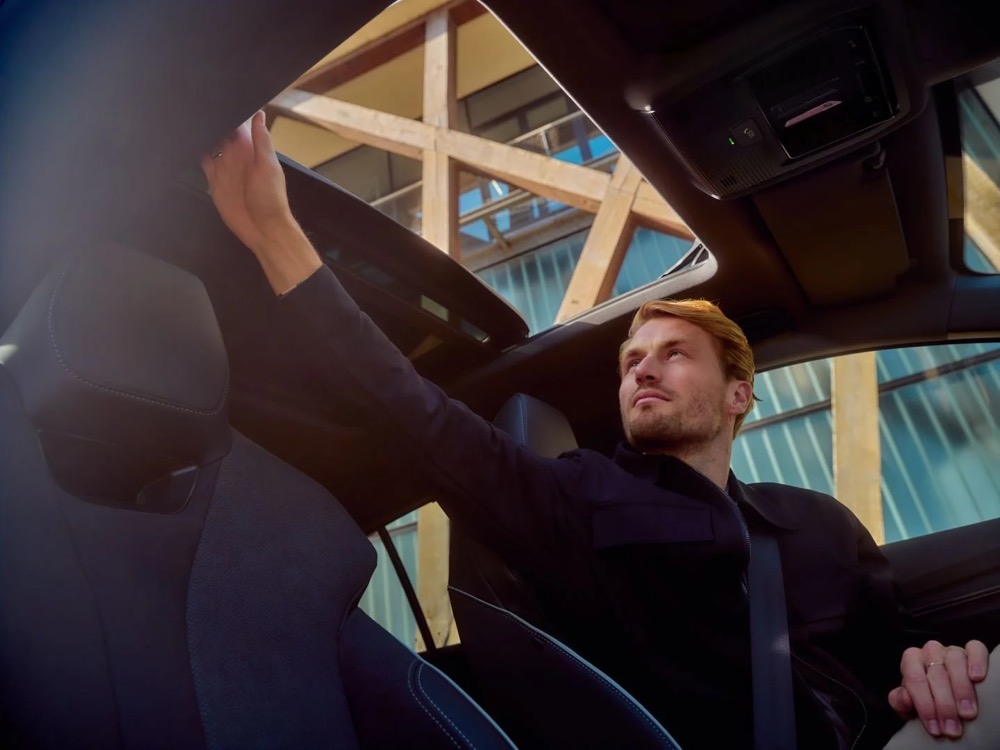 Mann öffnet während der Fahrt das Schiebedach, Shooting für Athlon Car Lease in Amsterdam
