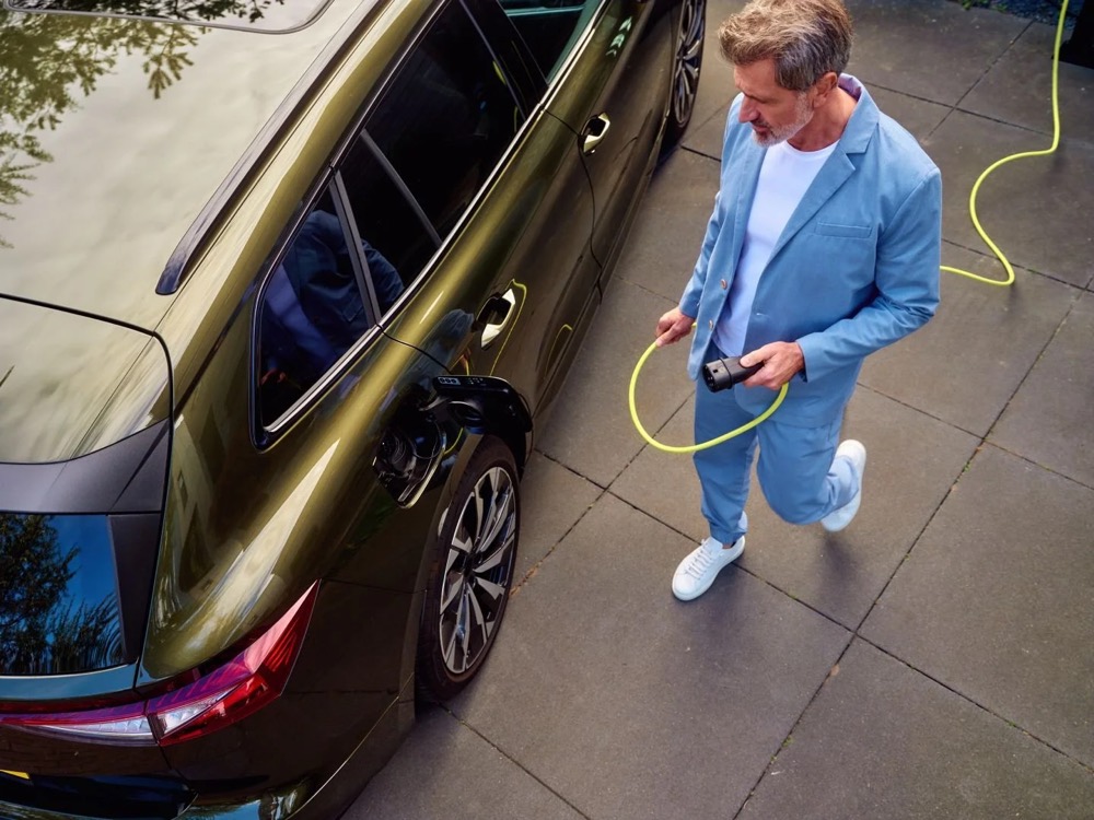 Mann steckt sein E-Auto an die Wallbox, Shooting für Athlon Car Lease in Amsterdam