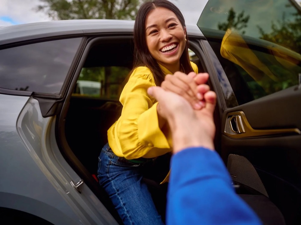 Frau steigt aus ihrem neuen Auto, Shooting für Athlon Car Lease in Amsterdam
