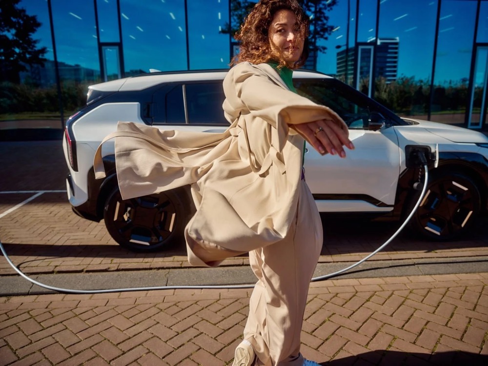 Frau an einer öffentlichen Ladestation an einem windigen Tag, Shooting für Athlon Car Lease in Amsterdam