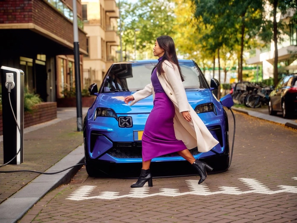 Frau geht auf eine öffentliche Ladesäule zu, Shooting für Athlon Car Lease in Amsterdam