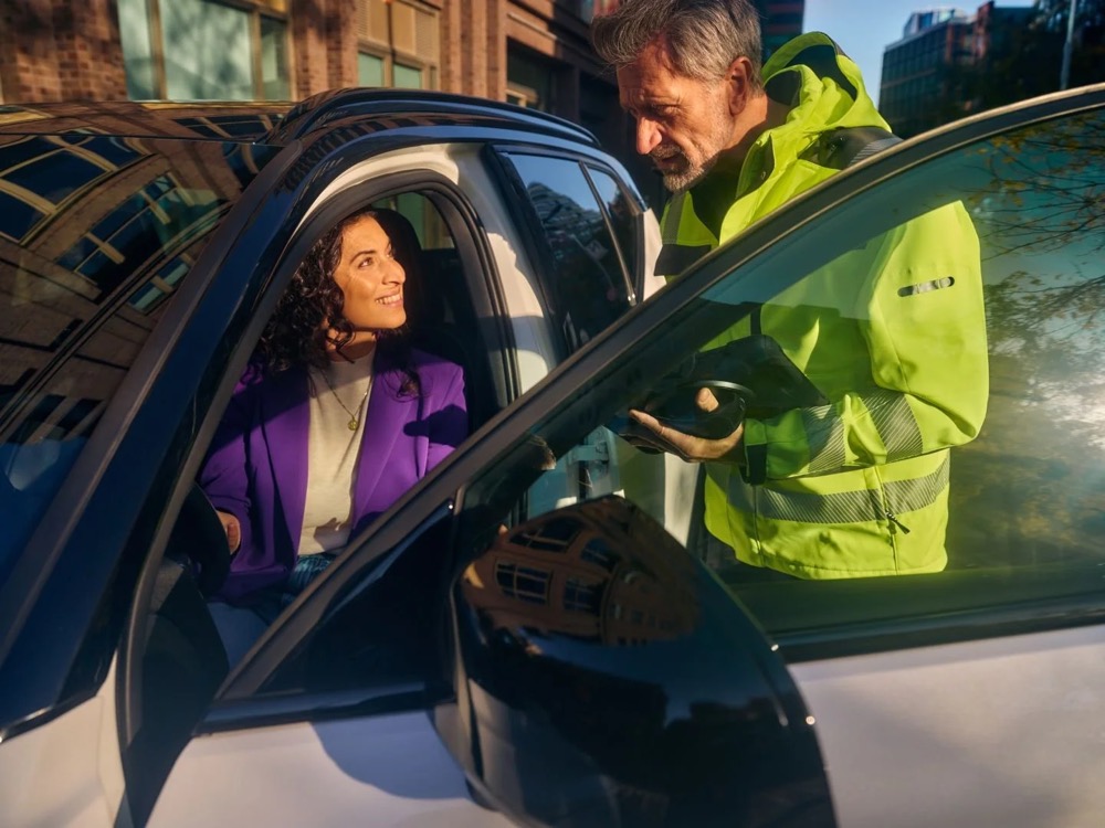Frau im Auto schaut zu einem Pannenhelfer, Shooting für Athlon Car Lease in Amsterdam