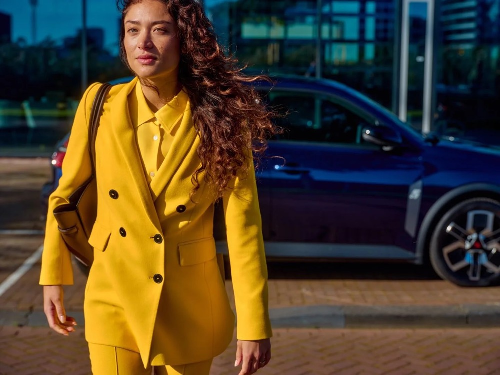 Frau geht in der Stadt von ihrem geparkten Auto weg, Shooting für Athlon Car Lease in Amsterdam