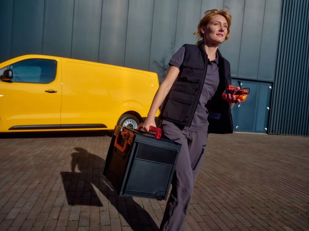 Technikerin geht von ihrem Transporter weg, Shooting für Athlon Car Lease in Amsterdam