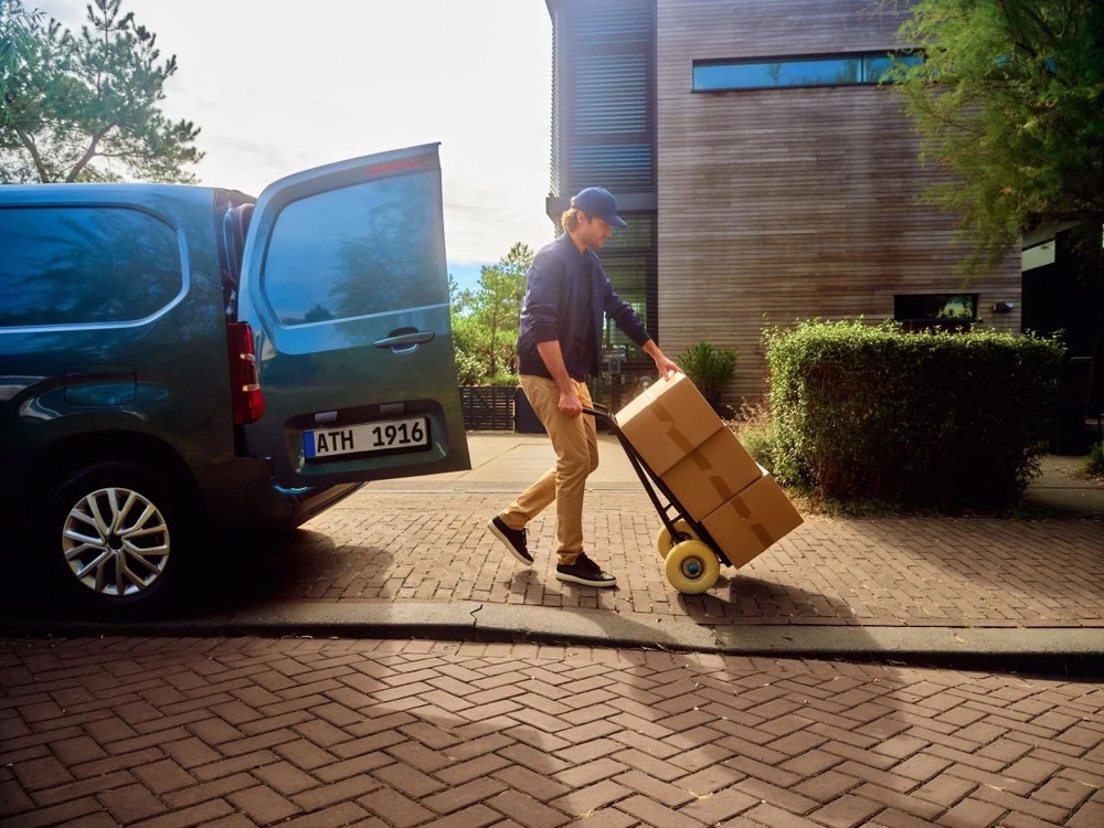 Paketfahrer neben seinem Transporter, Totale, Shooting für Athlon Car Lease in Amsterdam