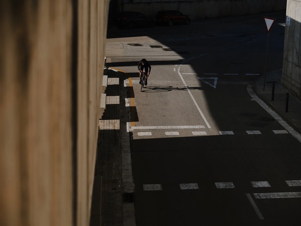Radfahrer fährt in Barcelona aus einer schattigen Unterführung, DIZO Bikes