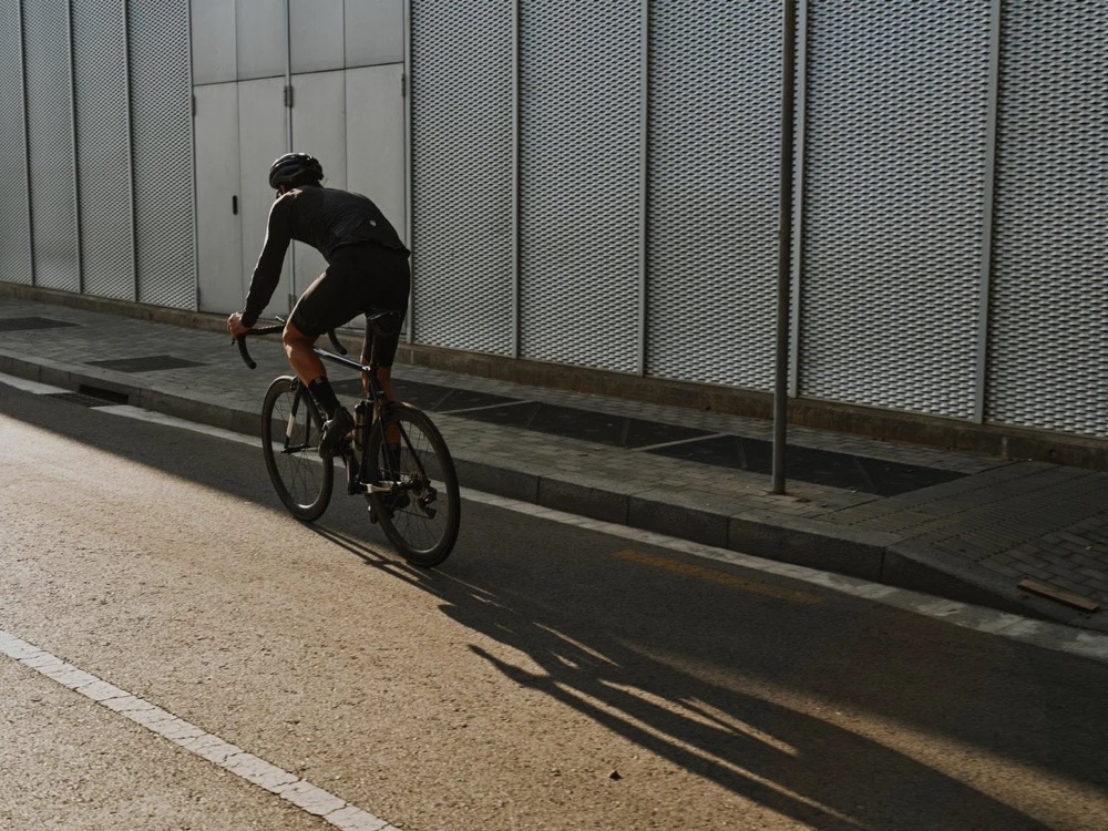 Radfahrer fährt in Barcelona an einer grauen Mauer entlang, DIZO Bikes
