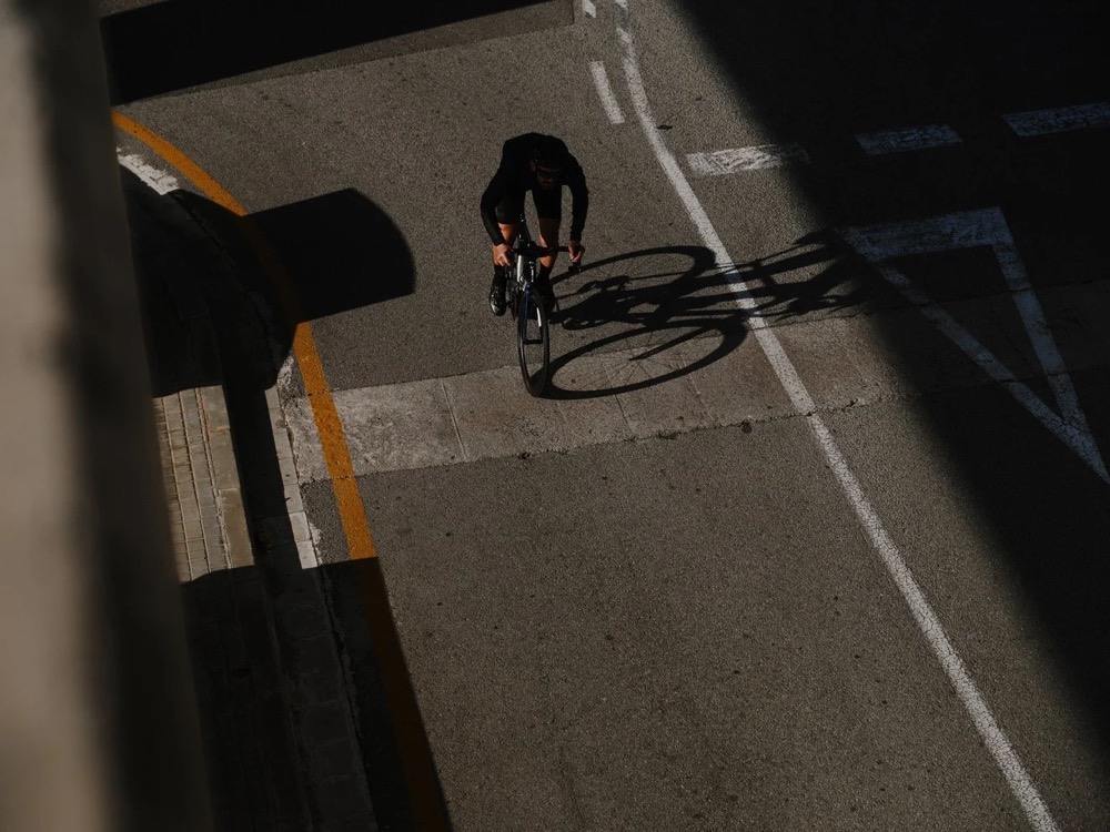 Radfahrer fährt in Barcelona an einer Mauer entlang, von oben, DIZO Bikes