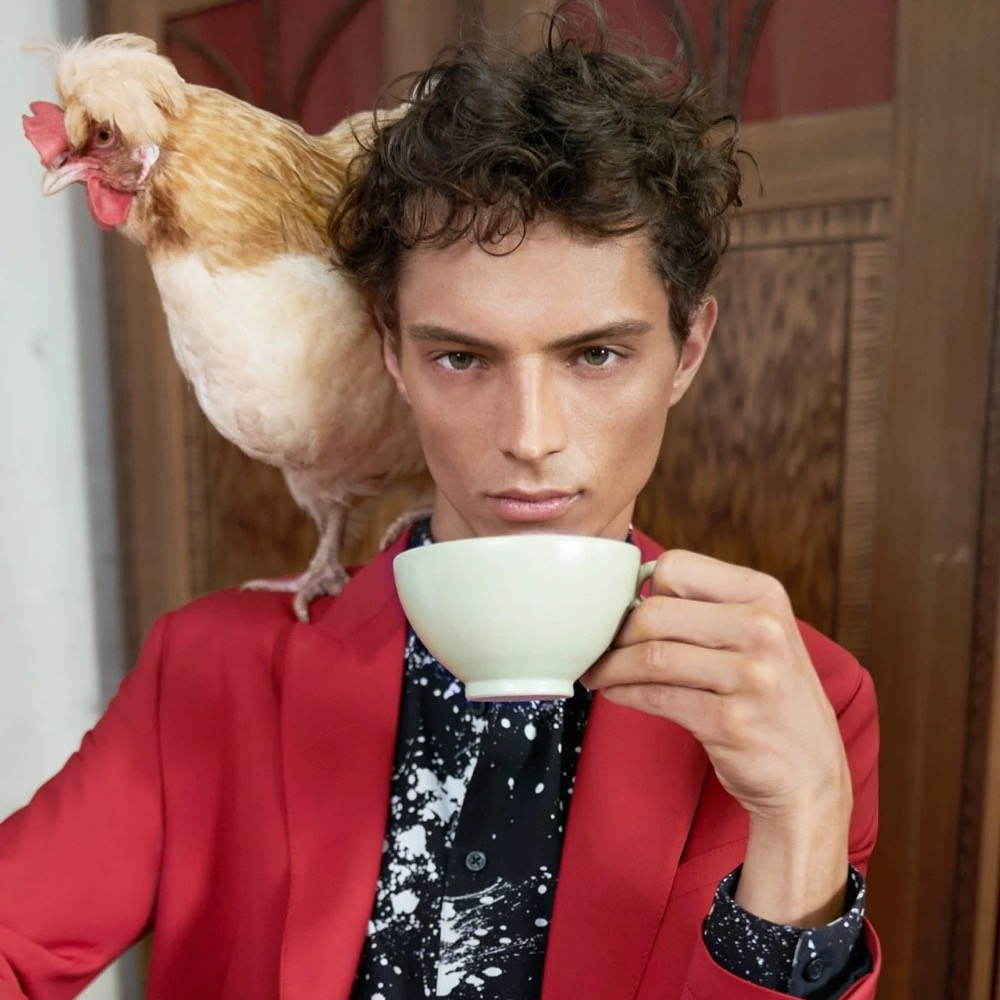 Model trinkt aus einer Tasse, ein Huhn auf der Schulter, Drykorn-Kampagne FS/SS 21 auf der SiHo Ranch
