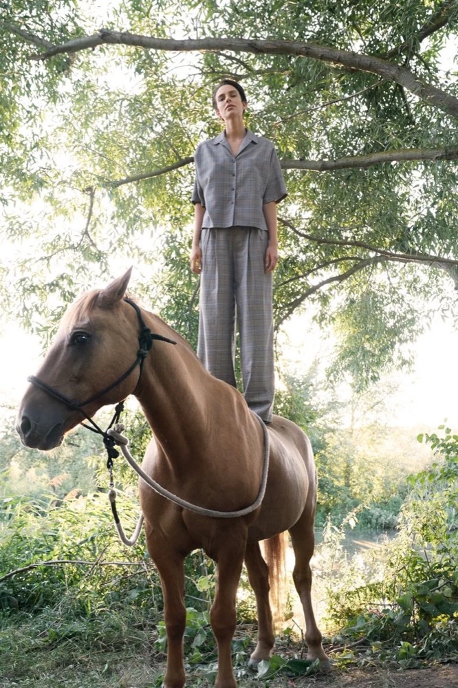 Model steht unter einem Baum auf einem Pferd, Drykorn-Kampagne FS/SS 21 auf der SiHo Ranch