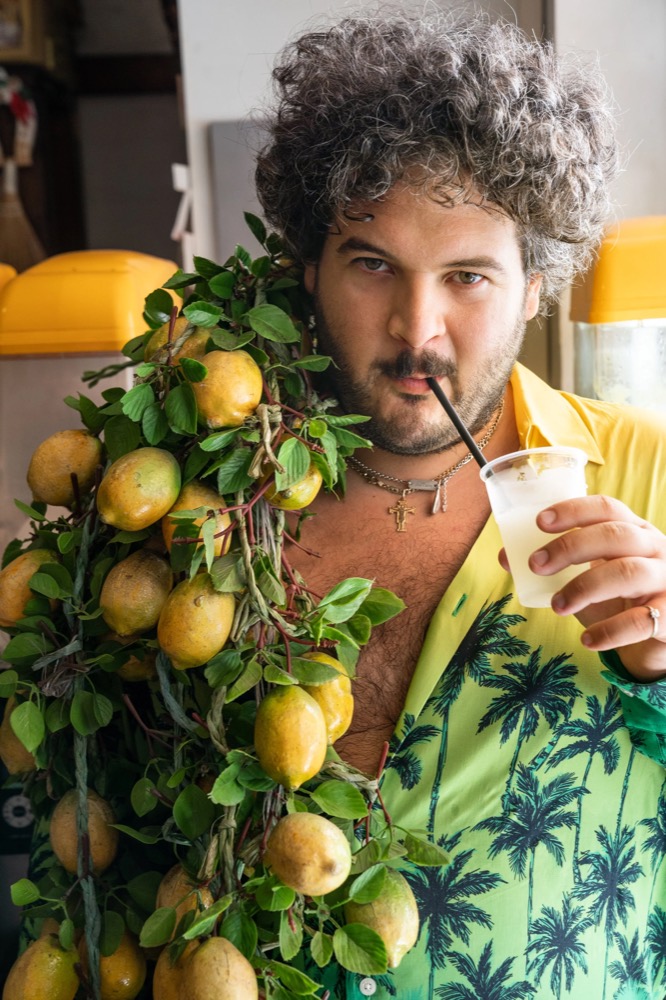 Model im Hemd mit Palmenprint neben einem Zitronenbaum, Drykorn-Kampagne FS/SS 23 in Neapel