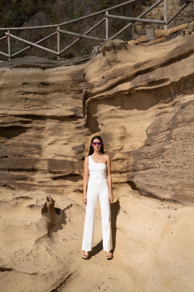 Model im weißen Jumpsuit vor Tuffstein, Drykorn-Kampagne FS/SS 23 in Neapel