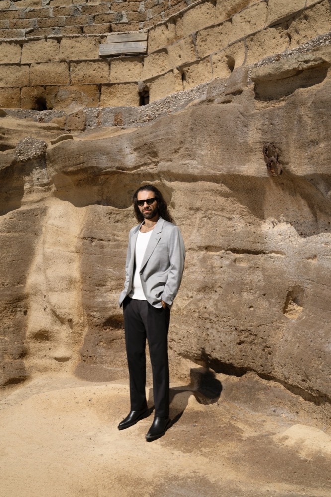 Model im grauen Blazer in einer Tuffsteinhöhle, Drykorn-Kampagne FS/SS 23 in Neapel