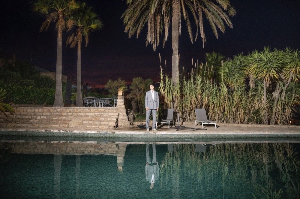 Model nachts an einem Pool mit Palmen, Drykorn-Kampagne FS/SS 24 Teil II auf Mallorca