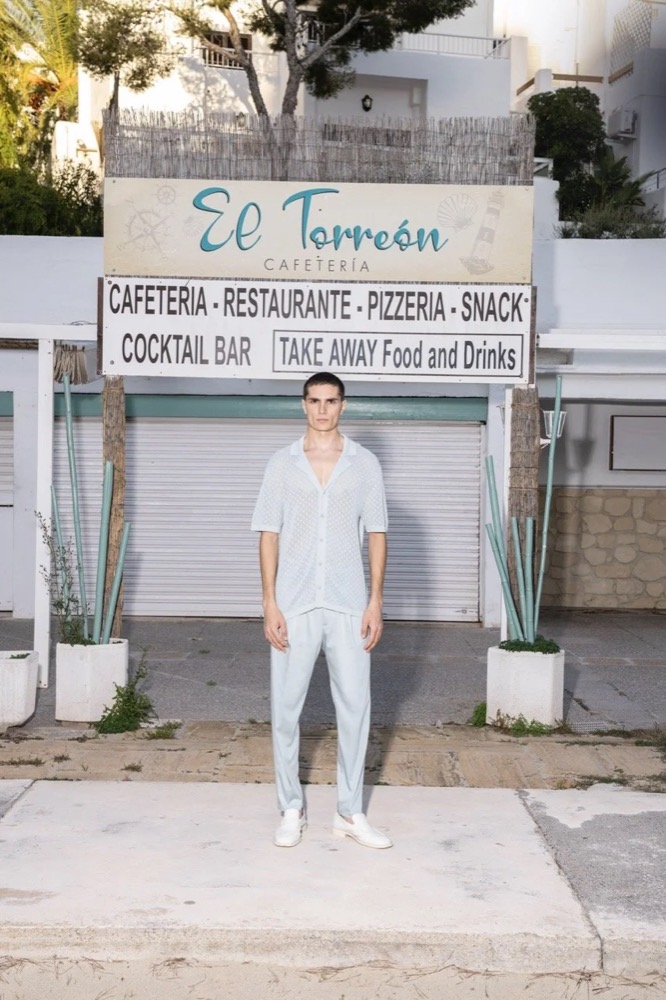 Model vor dem Schild eines Strandcafés, Drykorn-Kampagne FS/SS 24 Teil II auf Mallorca