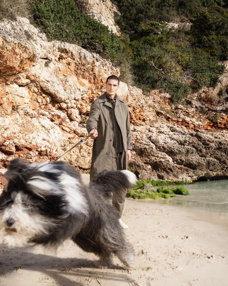 Model mit rennendem Hund an einem Felsstrand, Drykorn-Kampagne FS/SS 24 Teil II auf Mallorca