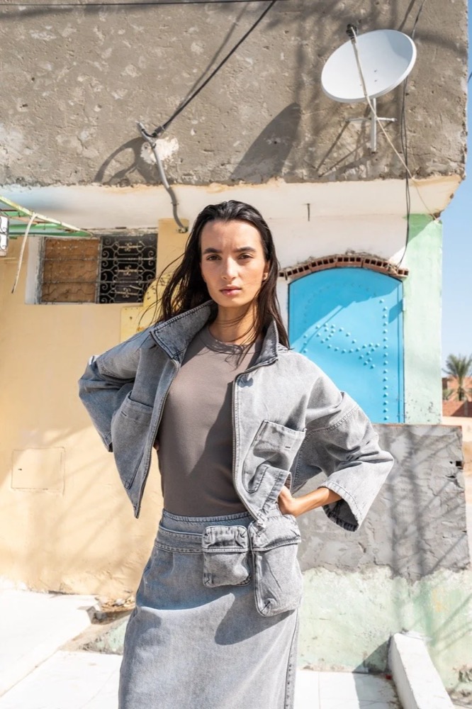 Model im grauen Denim-Look vor einer Satellitenschüssel, Drykorn-Kampagne FS/SS 24 in Tozeur, Tunesien