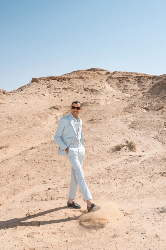 Model im hellen Anzug läuft durch Sanddünen, Drykorn-Kampagne FS/SS 24 in Tozeur, Tunesien