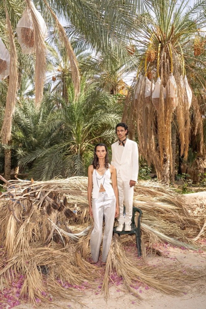 Zwei Models in einem Palmenhain zwischen trockenen Palmwedeln, Drykorn-Kampagne FS/SS 24 in Tozeur, Tunesien