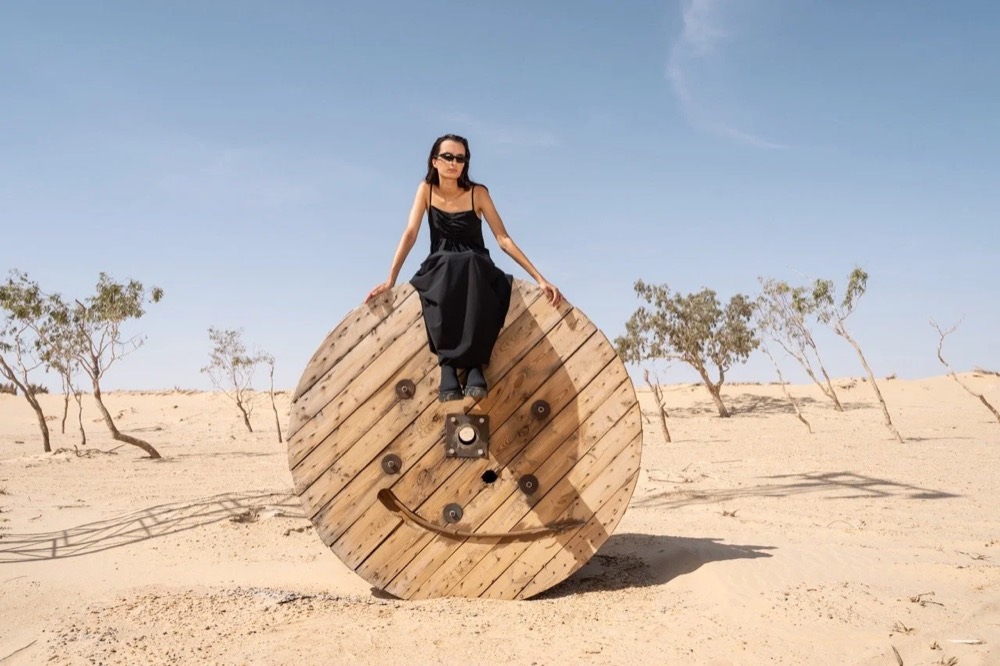 Model steht auf einem Heuballen in der Wüste, Drykorn-Kampagne FS/SS 24 in Tozeur, Tunesien