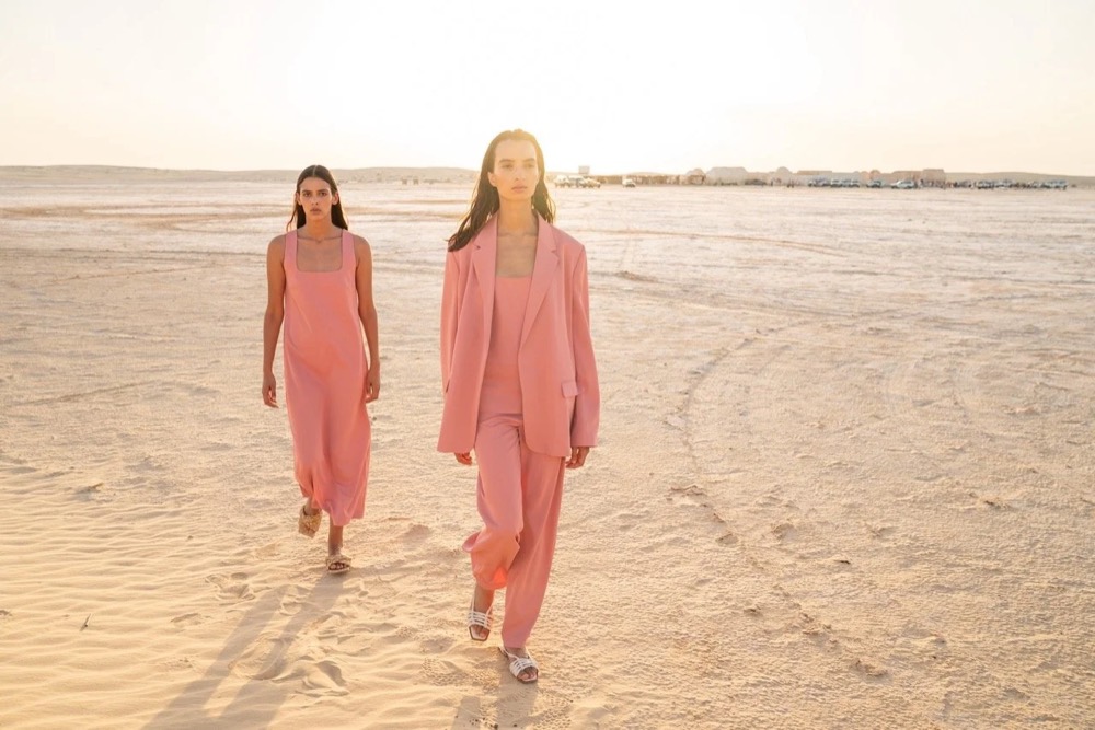 Zwei Models in Rosa am Strand bei Sonnenuntergang, Drykorn-Kampagne FS/SS 24 in Tozeur, Tunesien