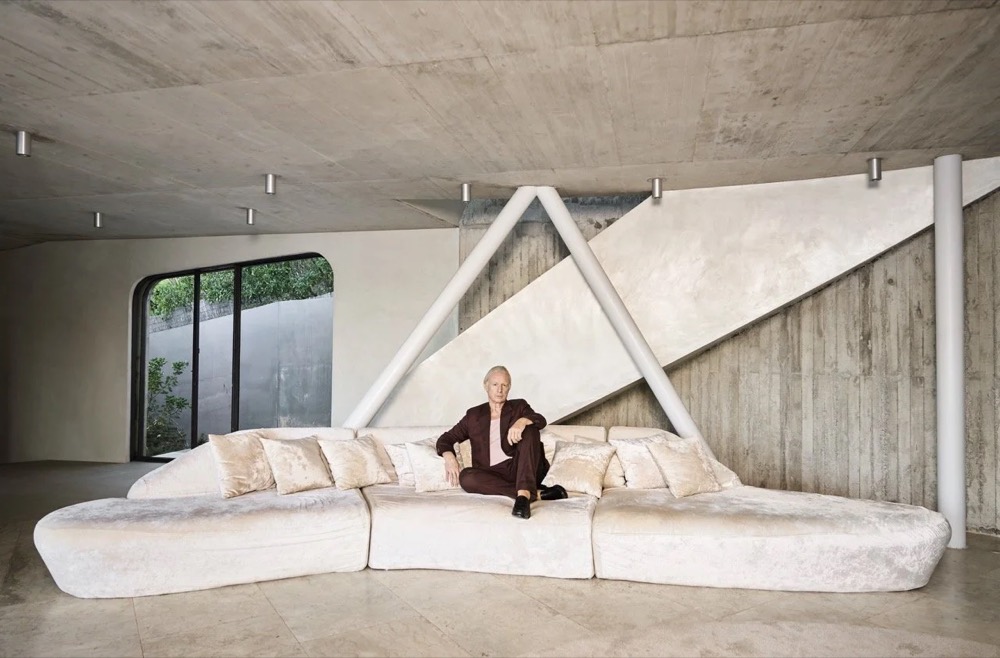 Model auf einem geschwungenen weißen Sofa in einer Villa, Drykorn-Kampagne FS/SS25 auf Ibiza