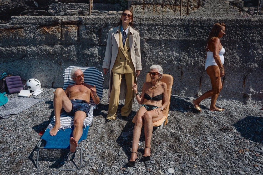 Gruppe von Models entspannt auf Felsen am Meer, Drykorn-Kampagne FS/SS26 in Genua