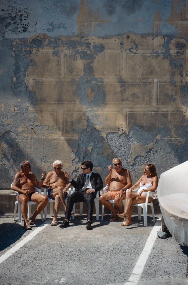 Models und Einheimische sitzen an einer alten Mauer, Drykorn-Kampagne FS/SS26 in Genua