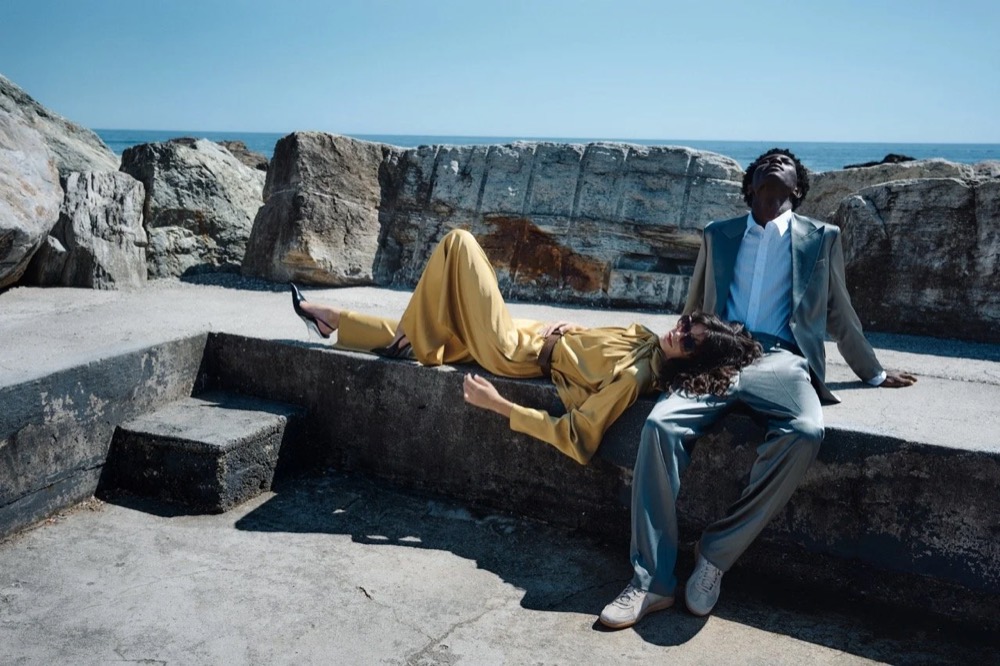 Model liegt auf einer steinernen Mole am Meer, Drykorn-Kampagne FS/SS26 in Genua