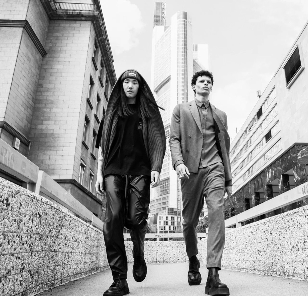 Schwarzweißaufnahme zweier Models zwischen Gebäuden, Drykorn-Kampagne HW/AW 2021 in Frankfurt