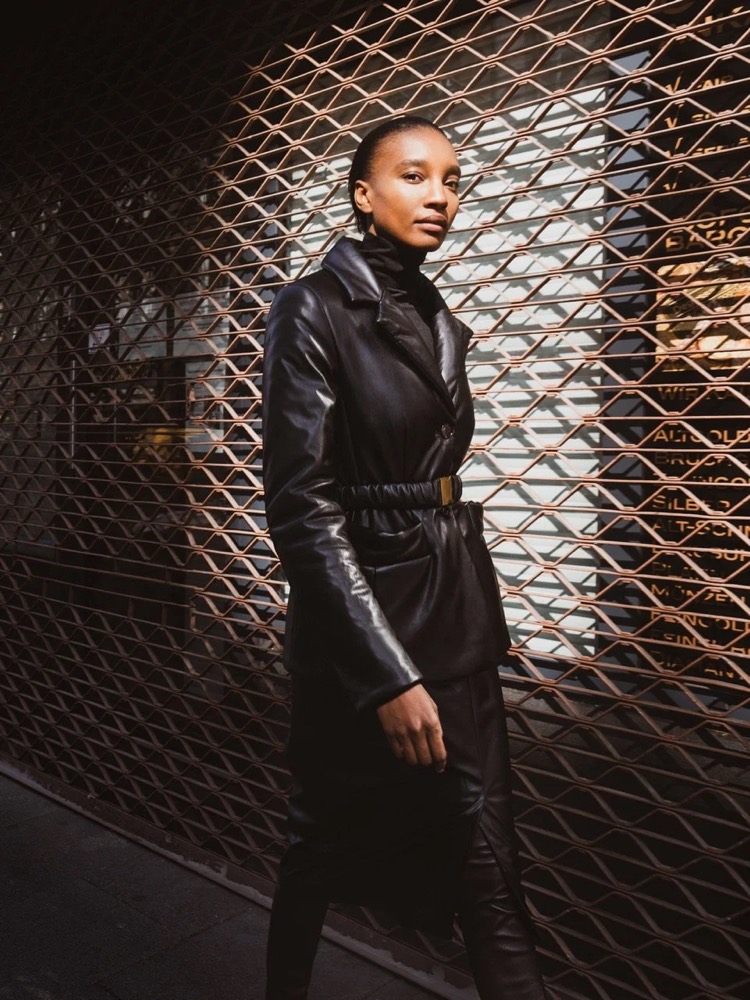 Model im schwarzen Ledermantel vor einem Metallgitter, Drykorn-Kampagne HW/AW 2021 in Frankfurt