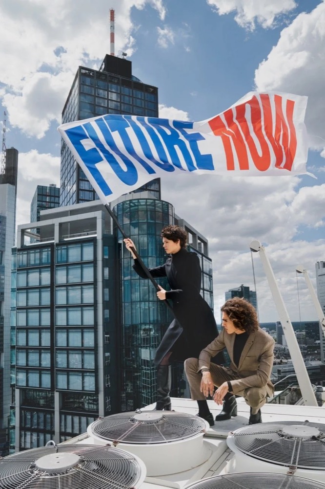 Zwei Models auf einem Dach mit einem „Future Now“-Banner, Drykorn-Kampagne HW/AW 20 in Frankfurt