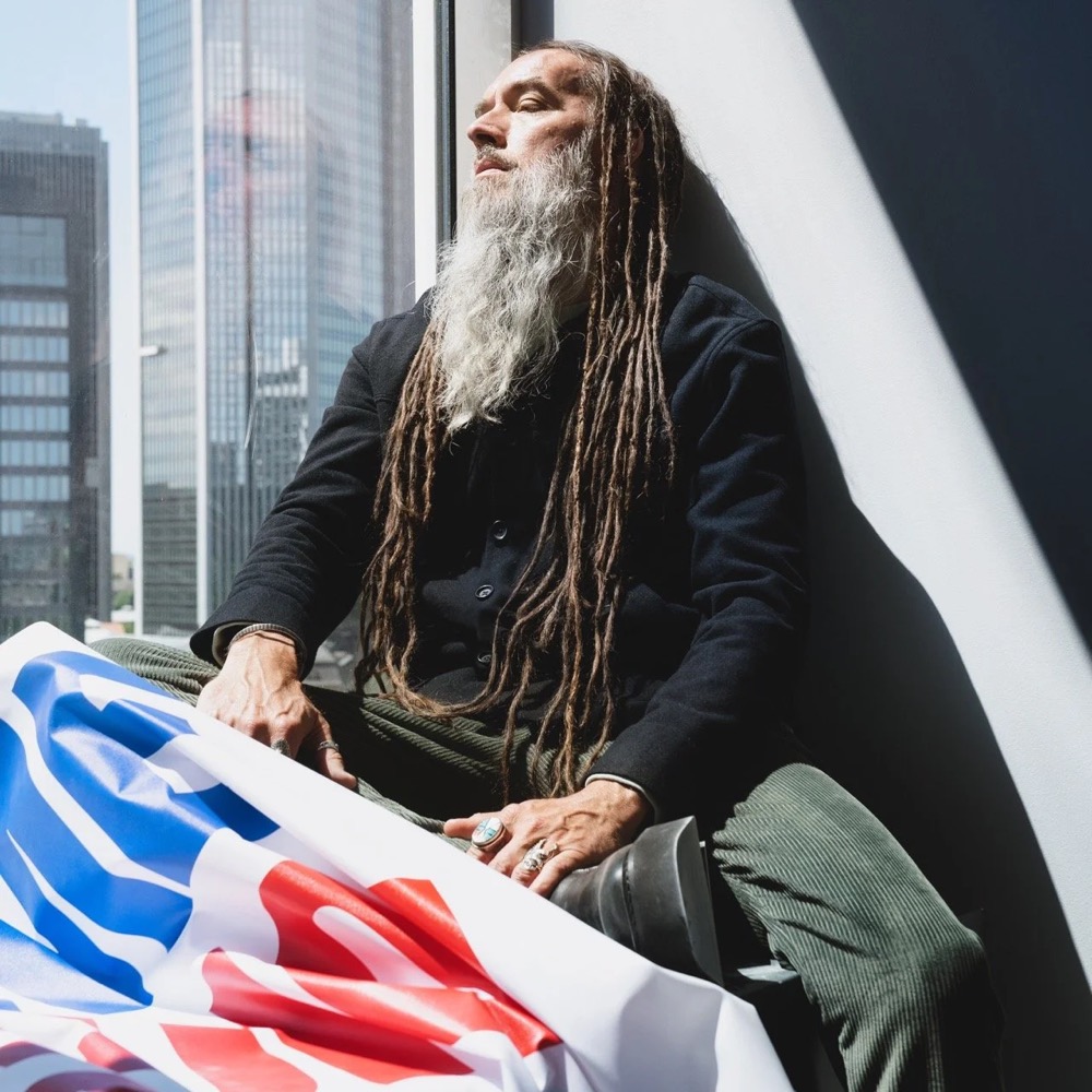 Bärtiges Model mit Protestschildern vor einem Hochhaus, Drykorn-Kampagne HW/AW 20 in Frankfurt