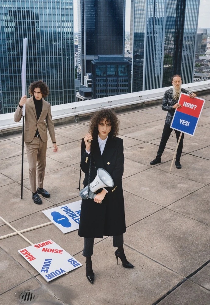 Models mit Protestschildern auf einem Dach zwischen Hochhäusern, Drykorn-Kampagne HW/AW 20 in Frankfurt