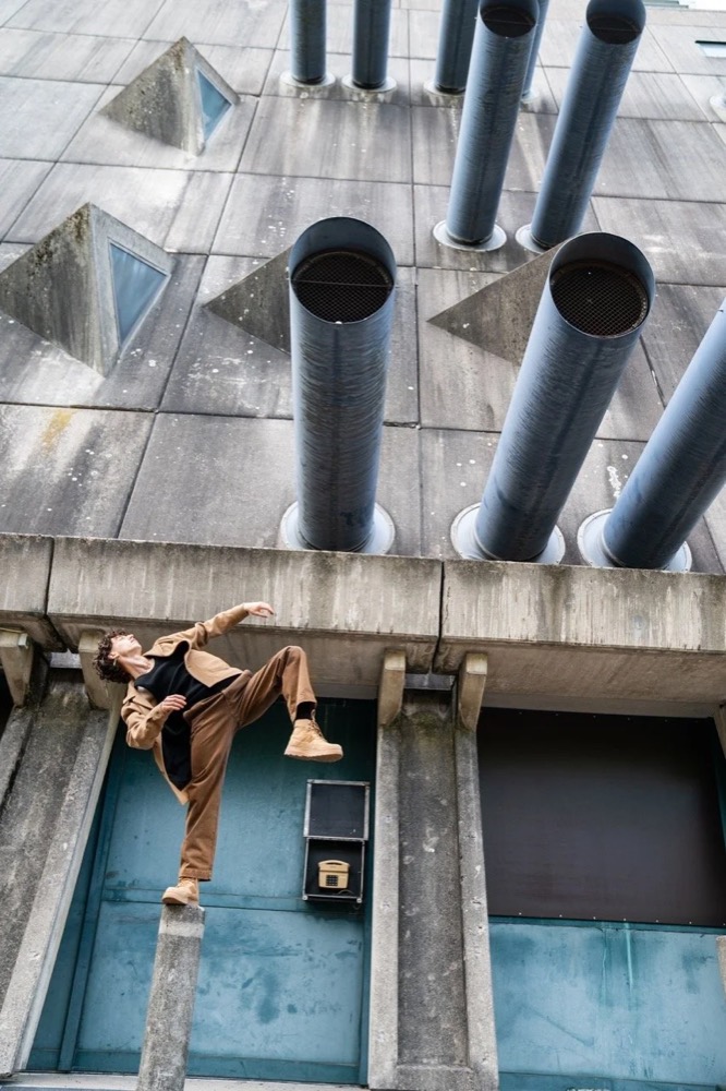 Model lehnt an einer Betonfassade mit Lüftungsrohren, Drykorn-Kampagne HW/AW 22