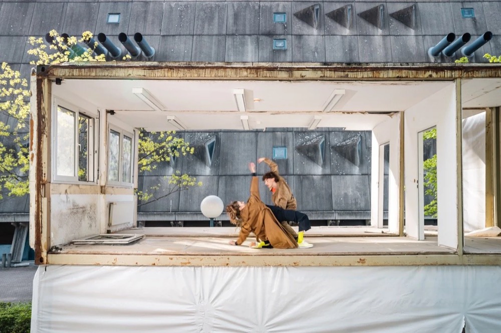 Model in einem großen Fenster eines modernistischen Gebäudes, Drykorn-Kampagne HW/AW 22