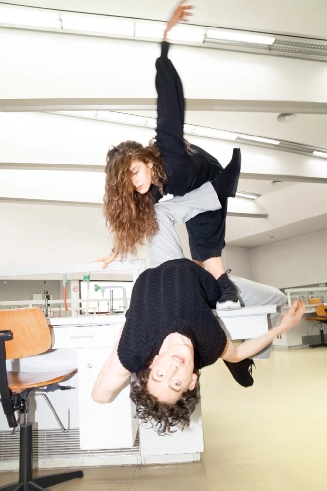 Model macht einen Handstand über einem anderen Model in einem Büro, Drykorn-Kampagne HW/AW 22