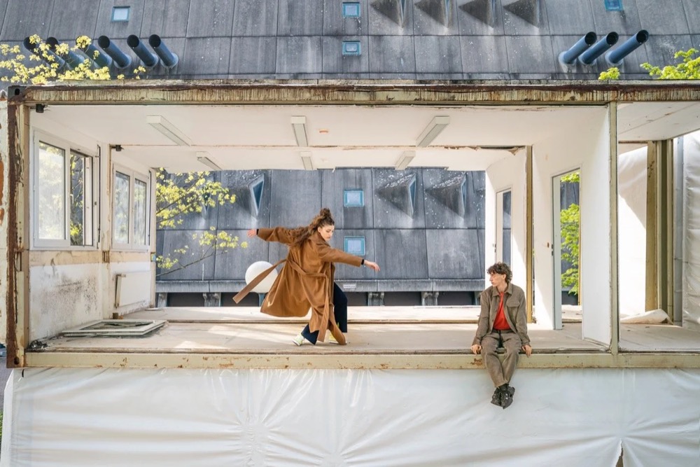 Model im großen Fenster eines modernistischen Gebäudes, Drykorn-Kampagne HW/AW 22