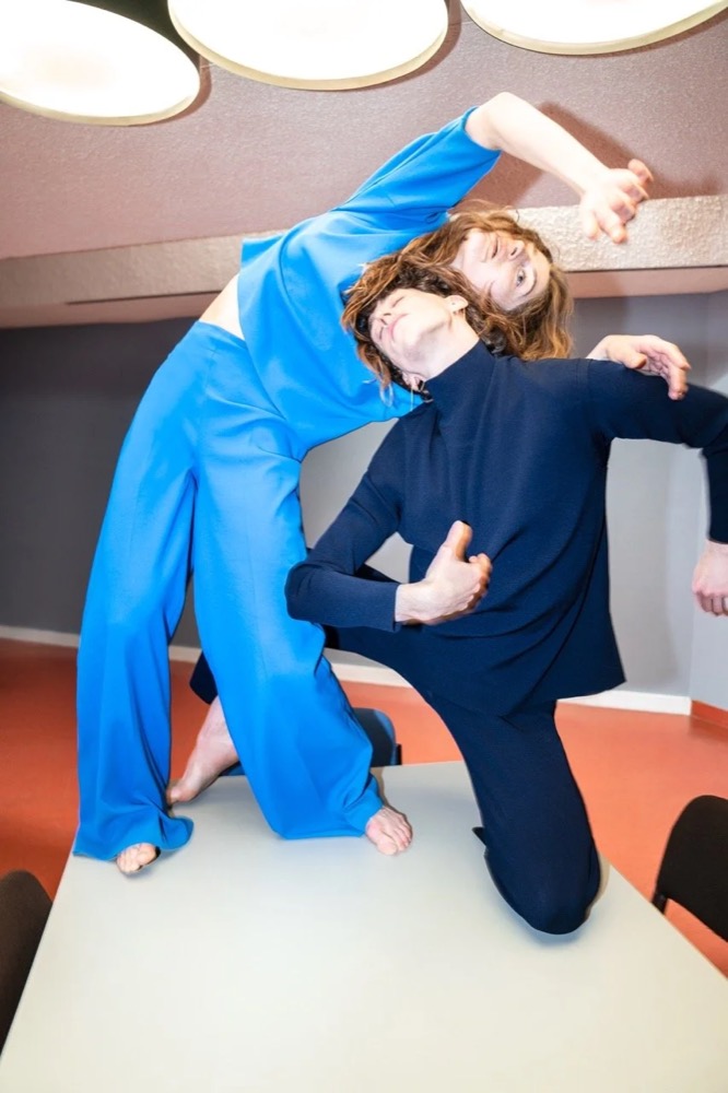 Zwei Models in Blau posieren in einem Raum mit runden Leuchten, Drykorn-Kampagne HW/AW 22