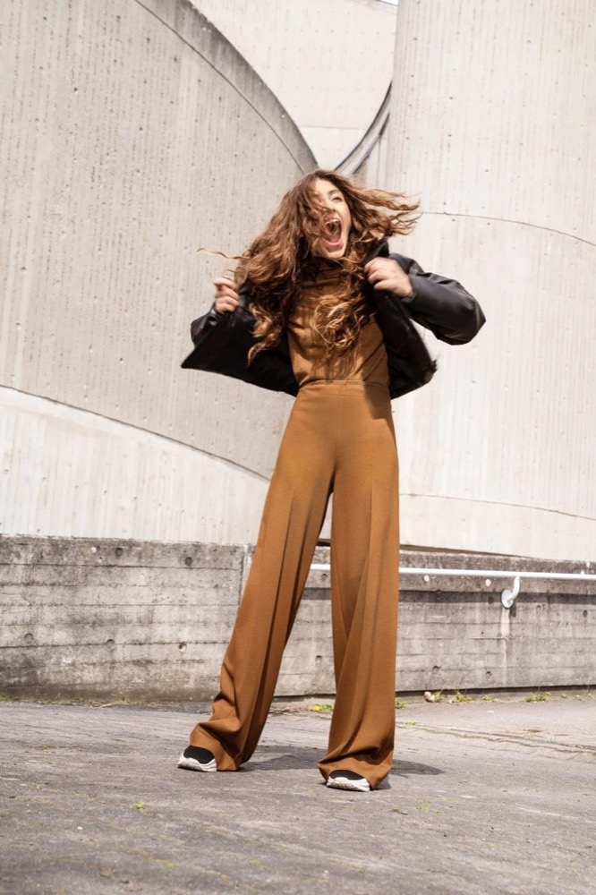 Model im braunen Anzug mit wehendem Haar auf einem Dach, Drykorn-Kampagne HW/AW 22