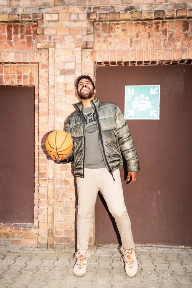 Model mit Basketball vor einem Backsteingebäude, Drykorn-Kampagne HW/AW 22