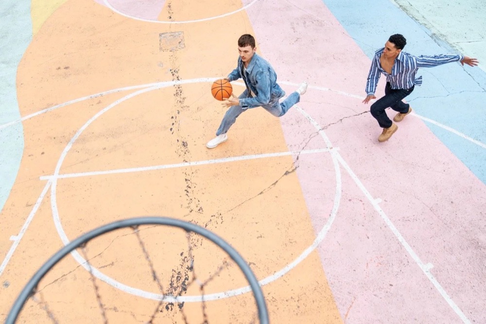 Zwei Models auf einem bunten Basketballplatz, von oben, Drykorn-Kampagne HW/AW 22