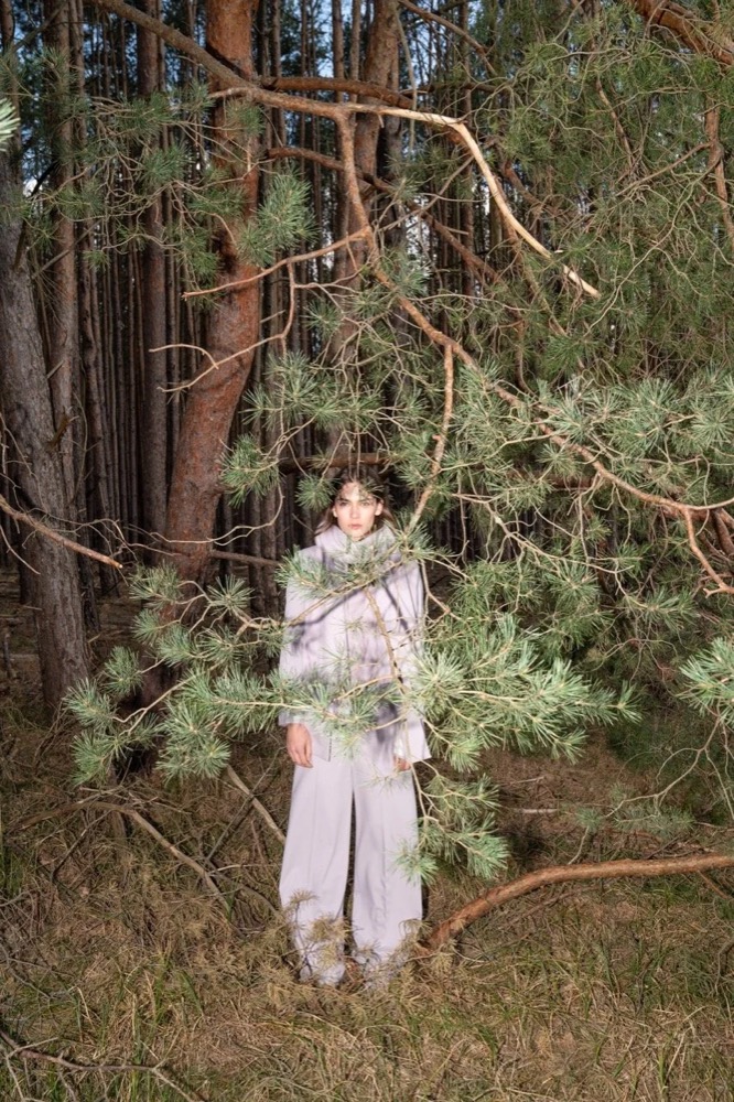 Model im cremefarbenen Outfit zwischen Bäumen, Drykorn-Kampagne HW/AW 22