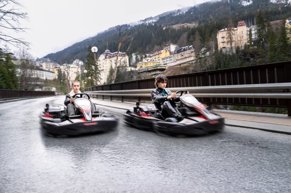Zwei Gokarts fahren auf einer Strecke in den Bergen, Drykorn-Kampagne HW/AW 23 in Bad Gastein