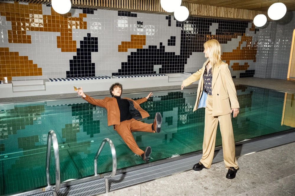 Zwei Models an einem Retro-Hallenbad, Drykorn-Kampagne HW/AW 23 in Bad Gastein
